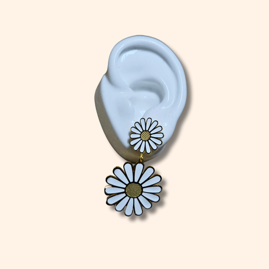 Close-up of a person wearing Roots Jewellery's White Daisy Bloom Earrings, an elegantly crafted statement piece in stainless steel. The neutral background enhances the design as the person is slightly turned to the side, allowing the earrings to effortlessly stand out.