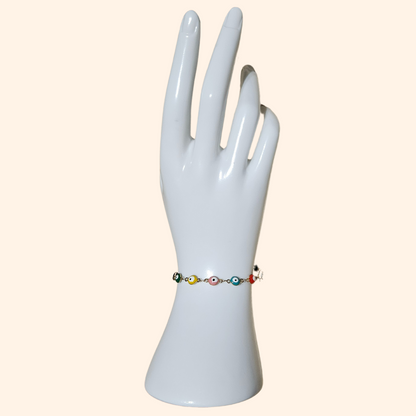 The Evil Eye Bracelet - Rainbow by Roots Jewellery features a gold chain adorned with eye-shaped beads in pink, black, yellow, and green, offering both protection and style.