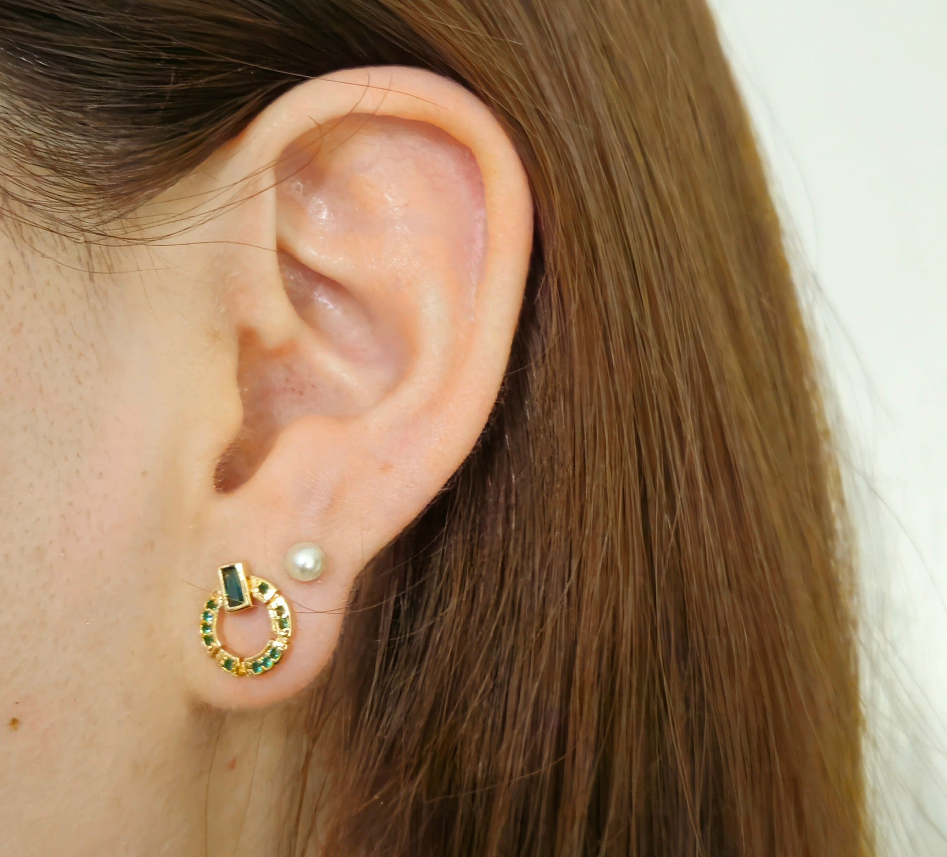 These elegant Natural Green Zircon Earrings by Roots Jewellery feature a gold-plated finish, highlighted by a distinctive circular design adorned with a striking rectangular green zircon stone at the top.