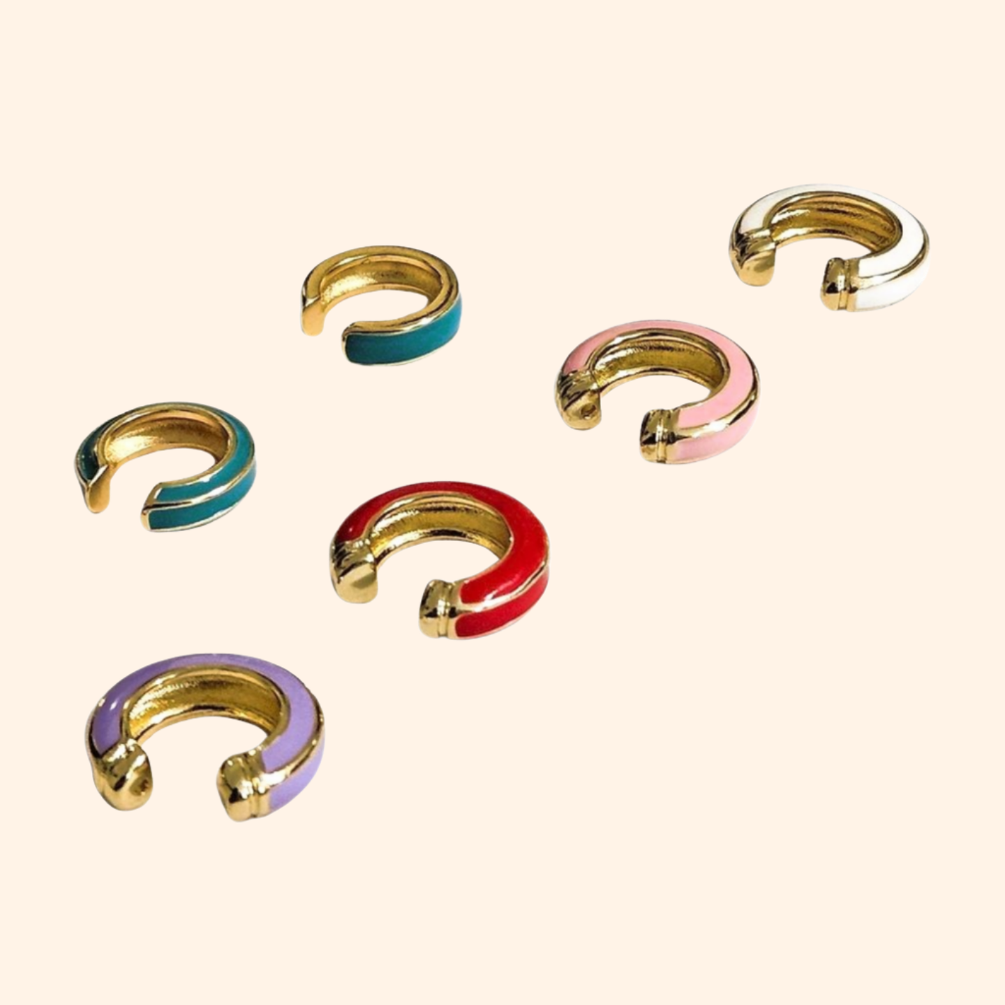 The Single Colour C Shape - Ear Cuff by Roots Jewellery is a small gold and teal ear cuff that elegantly showcases its intricate gold design, set against a beige background, highlighting this exquisite jewelry accessory.