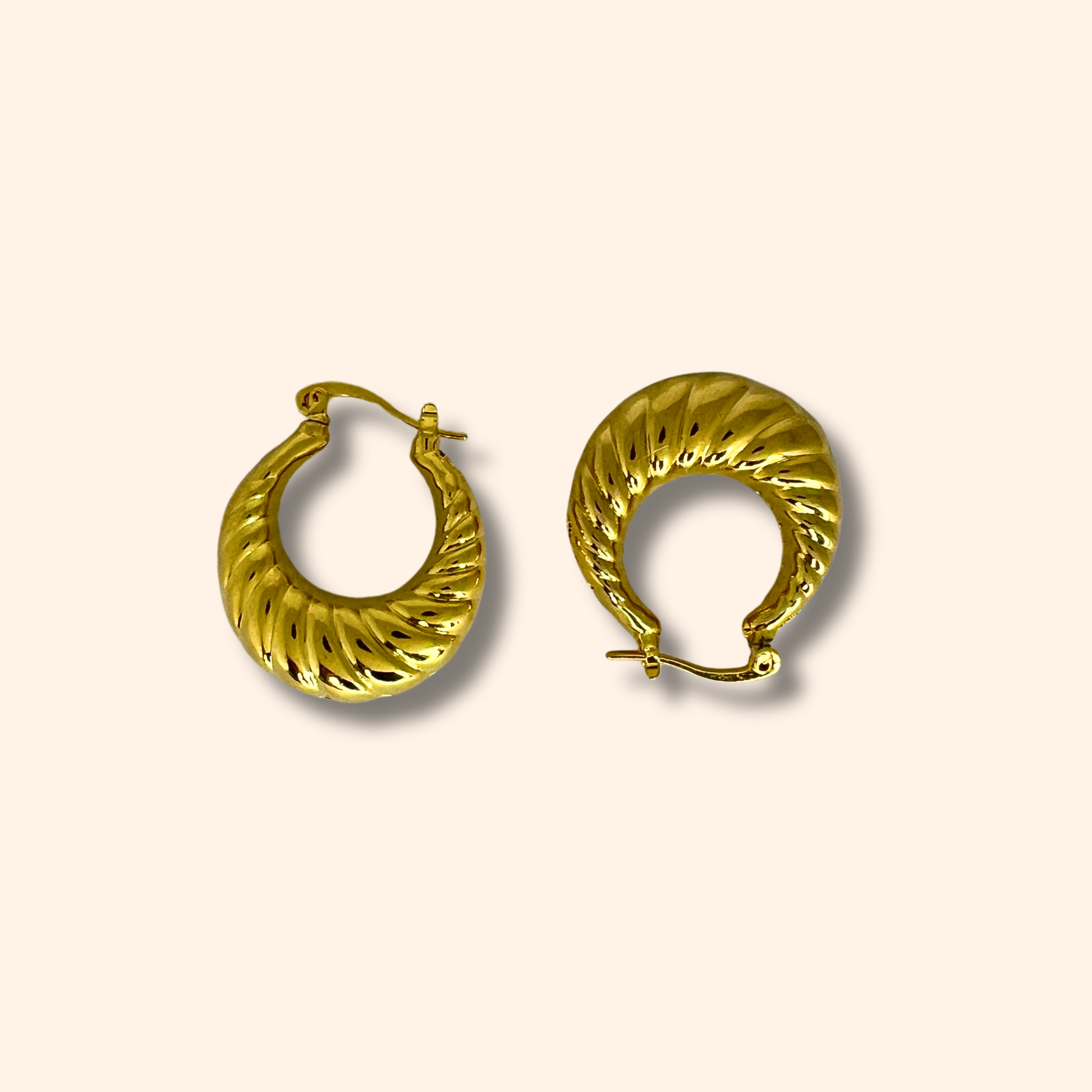 A pair of luxurious Gold Croissant Hoop Earrings from Roots Jewellery, boasting a textured, spiral design set against a neutral background.