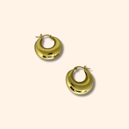 The Classic Gold Chunky Hoop Earrings by Roots Jewellery exude timeless elegance against a plain background.