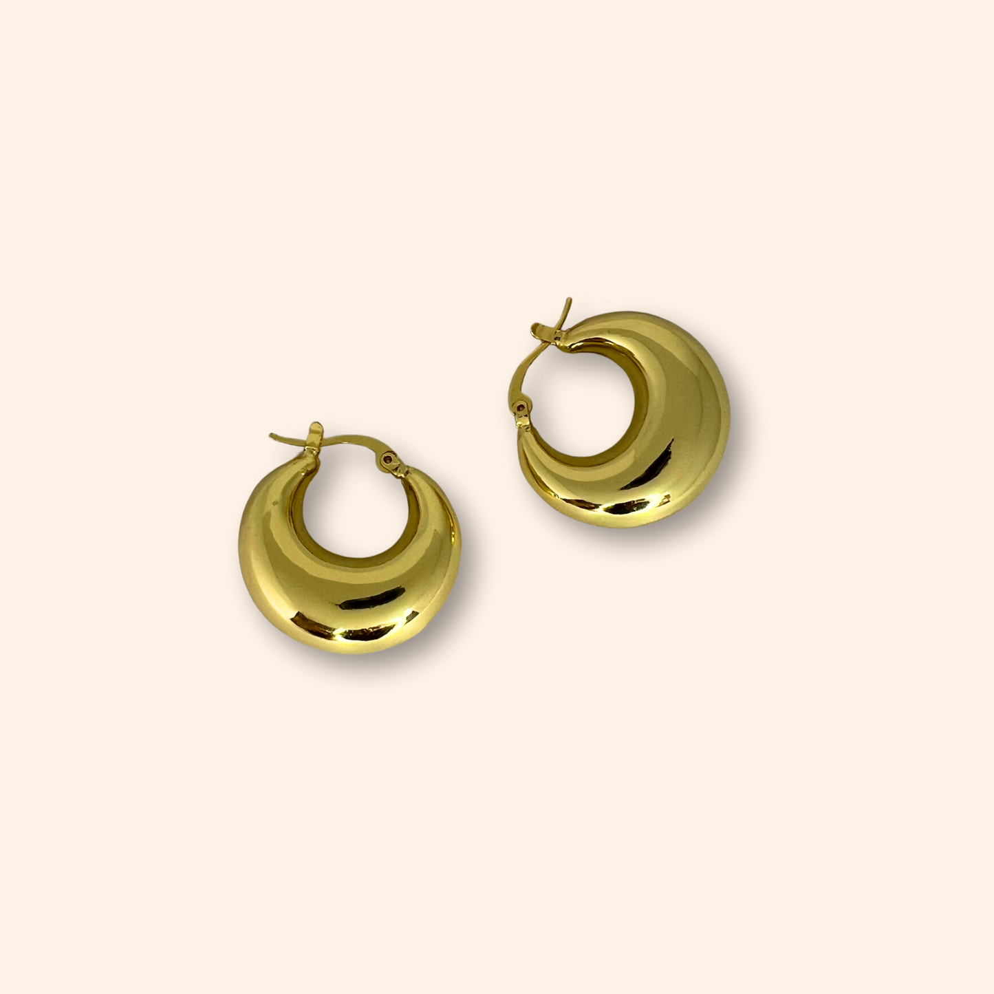 The Classic Gold Chunky Hoop Earrings by Roots Jewellery exude timeless elegance against a plain background.