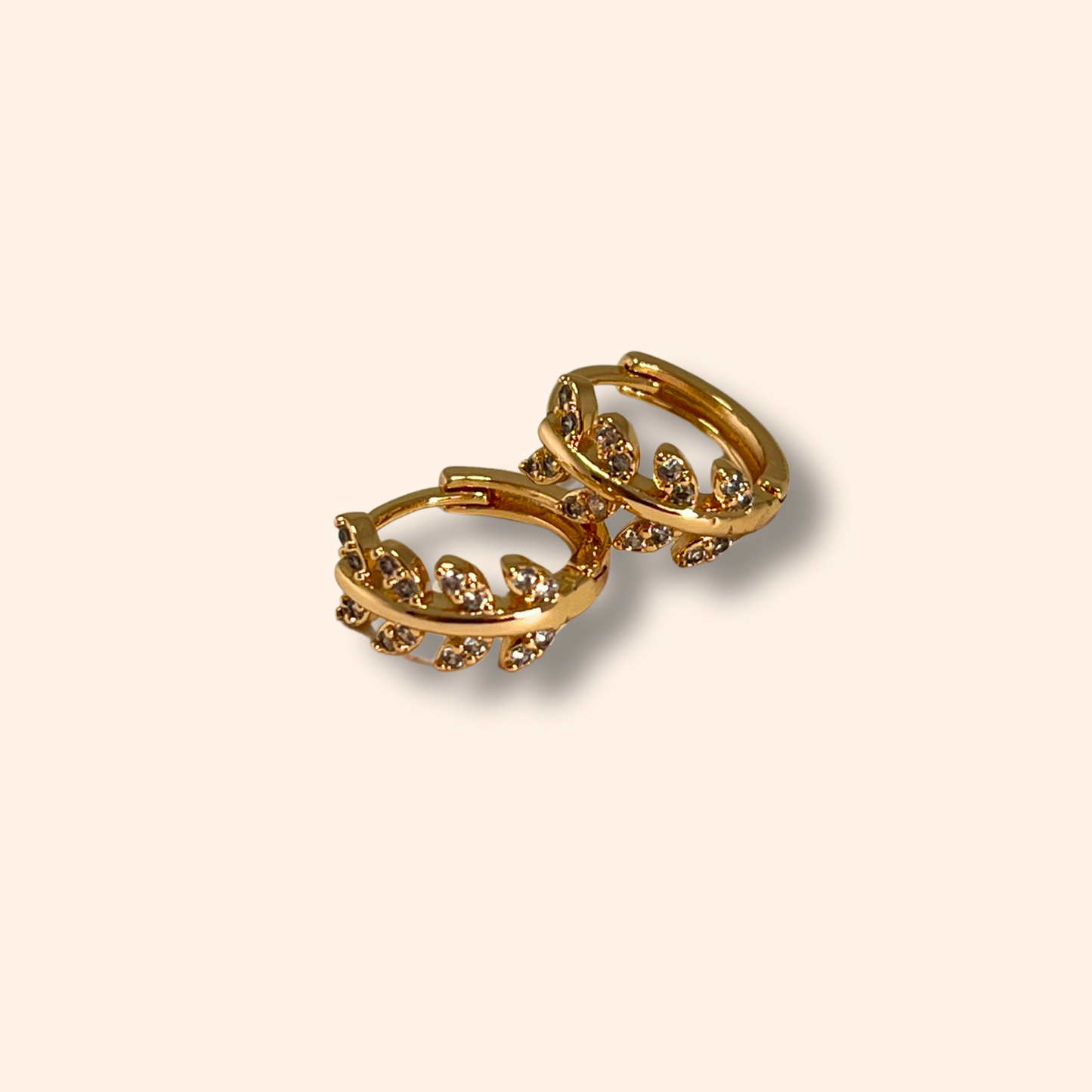 The Gold Leaf Vine Crystal Hoop Earrings by Roots Jewellery exude nature-inspired elegance on a plain background.