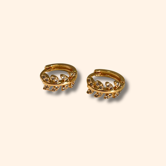 The Gold Leaf Vine Crystal Hoop Earrings by Roots Jewellery exude nature-inspired elegance on a plain background.