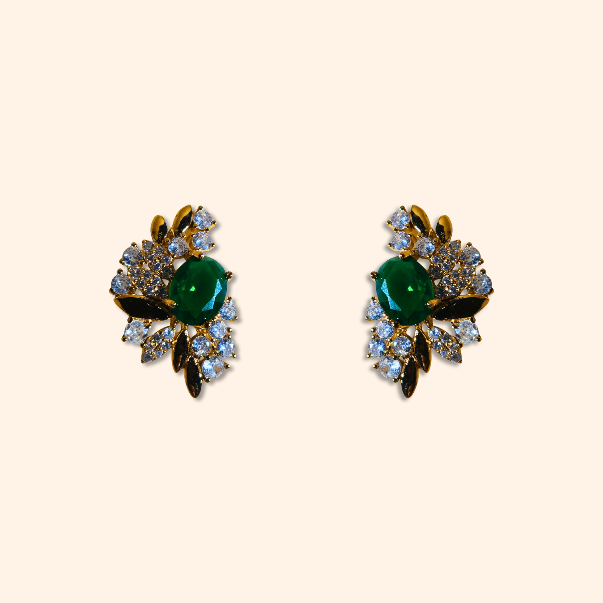 Behold the Emerald Floral Gold Earrings by Roots Jewellery, a stunning pair of vintage-inspired earrings featuring intricate floral designs with emerald green central stones surrounded by cubic zirconia.