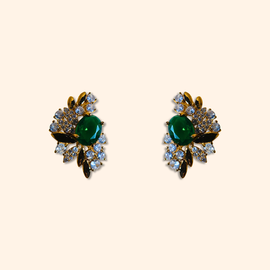 Behold the Emerald Floral Gold Earrings by Roots Jewellery, a stunning pair of vintage-inspired earrings featuring intricate floral designs with emerald green central stones surrounded by cubic zirconia.