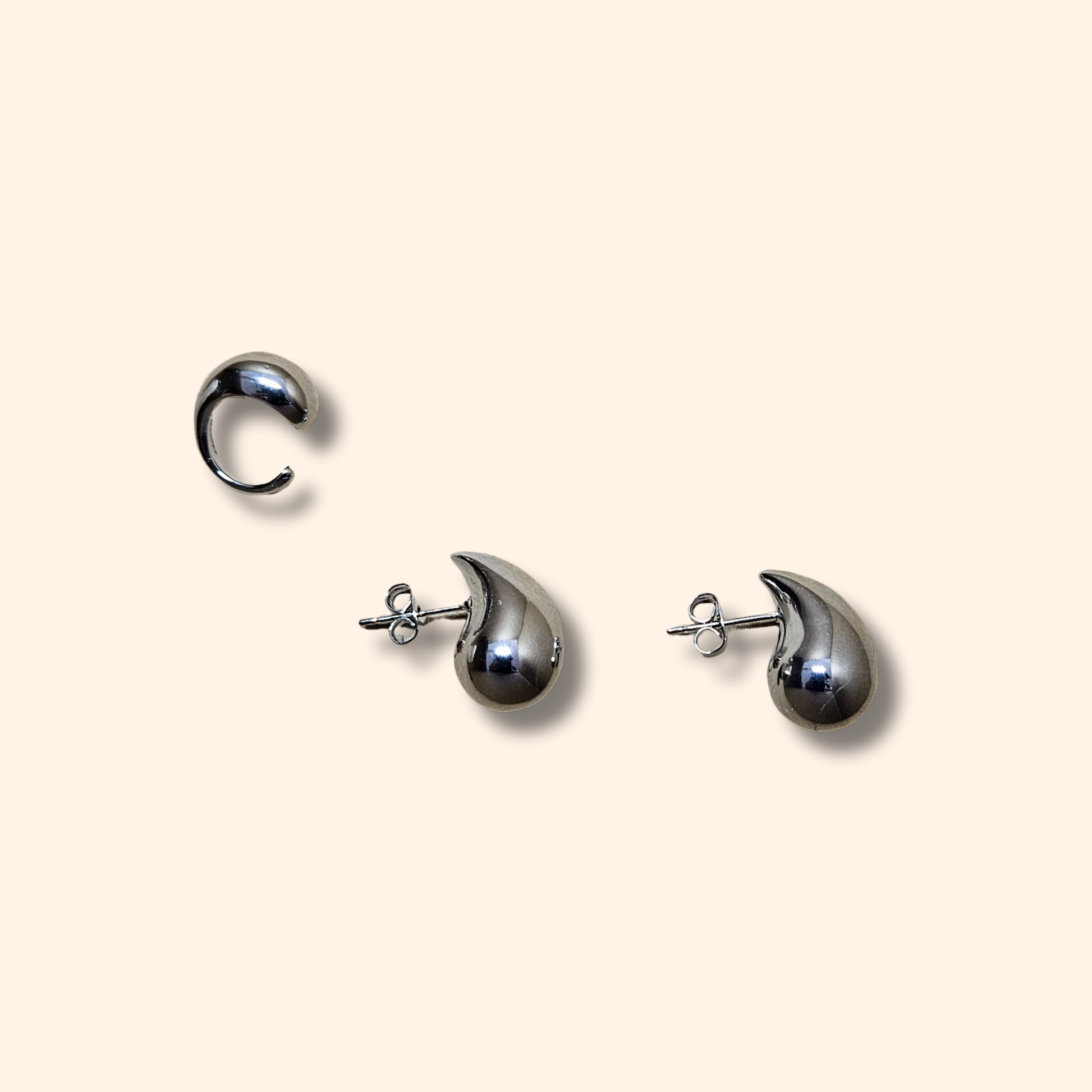 Teardrop Earrings by Roots Jewellery, crafted in gold or silver with a graceful curve that evokes an ear cuff, are showcased against a light background.