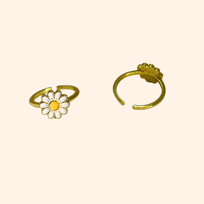 Explore the Daisy Gold Ring by Roots Jewellery, a striking piece adorned with a white and yellow daisy set against a sleek, neutral background.