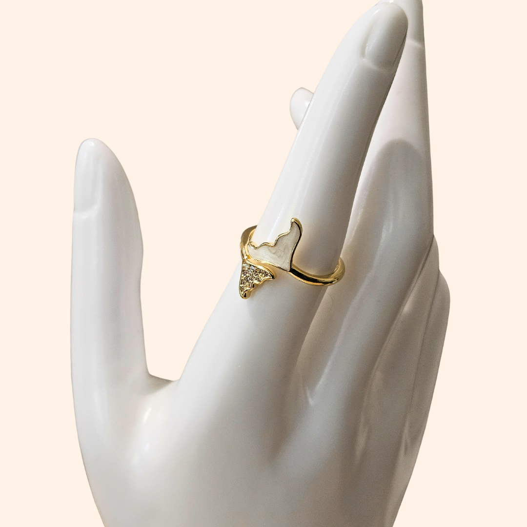 Introducing the Whale Tail - Gold & White Ring by Roots Jewellery, featuring an imaginative design reminiscent of a whimsical butterfly. This gold ring highlights one wing in pristine white and the other sparkling with twinkling gems, all enhanced by rhodium plating for an added touch of elegance. Set against a light backdrop, it beautifully captures the exquisite delicacy of nature's creations.