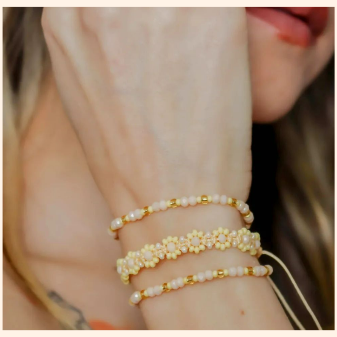 The mannequin elegantly showcases the Golden Dawn Beaded 3-Set Bracelet from Roots Jewellery, with its gold accents and pearls shimmering in harmony with subtle pastel yellows.