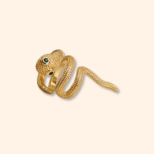 The Little Snake Ear Cuff by Roots Jewellery is a captivating fashion accessory, featuring a snake-shaped design with emerald-colored eyes that stands out beautifully against a light background.