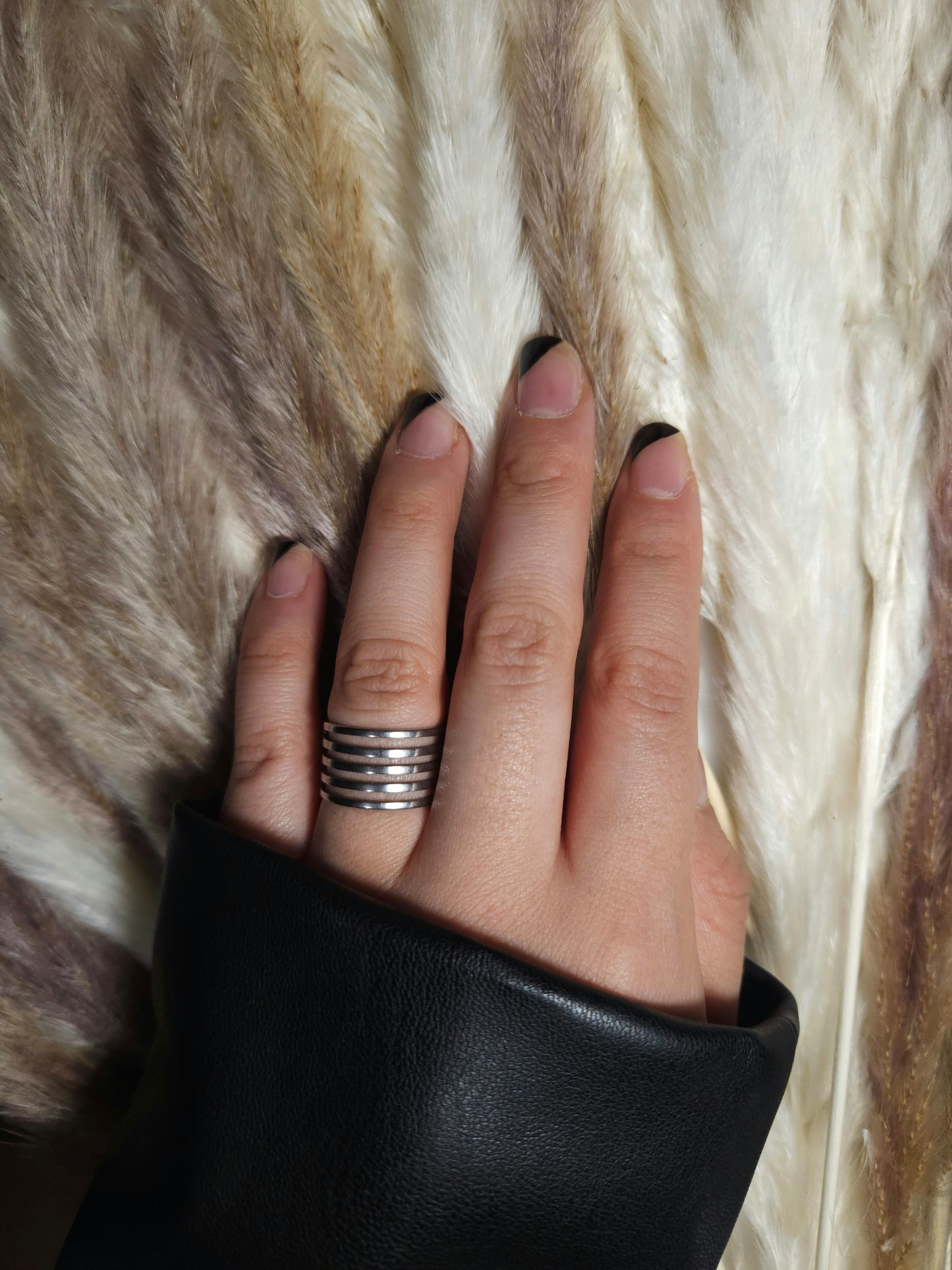 A Circle Ring from Roots Jewellery, featuring a silver color with multiple horizontal cutouts and an open back design, set against a neutral background.