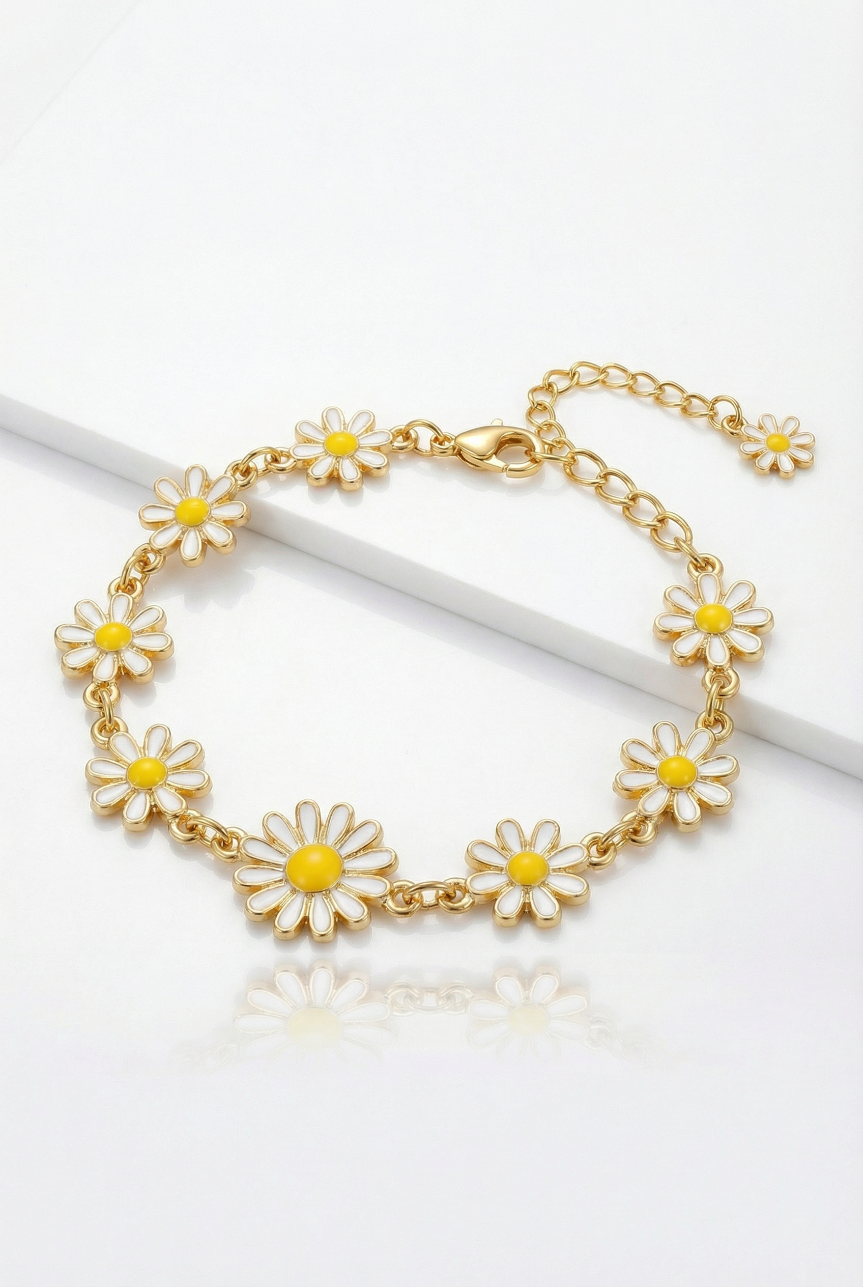Gold bracelet with daisy flower charms on a white background